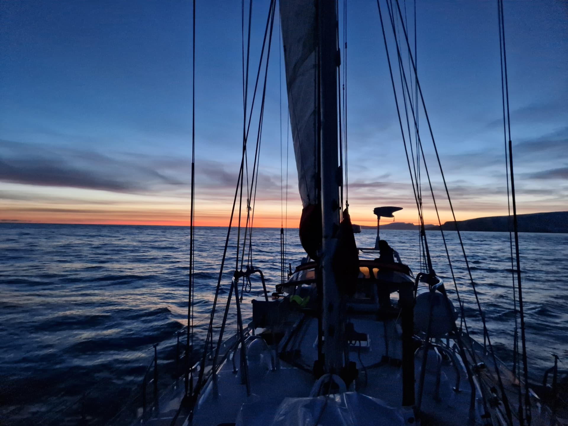 Boreal yacht sailing through winter twilight near Tromsø