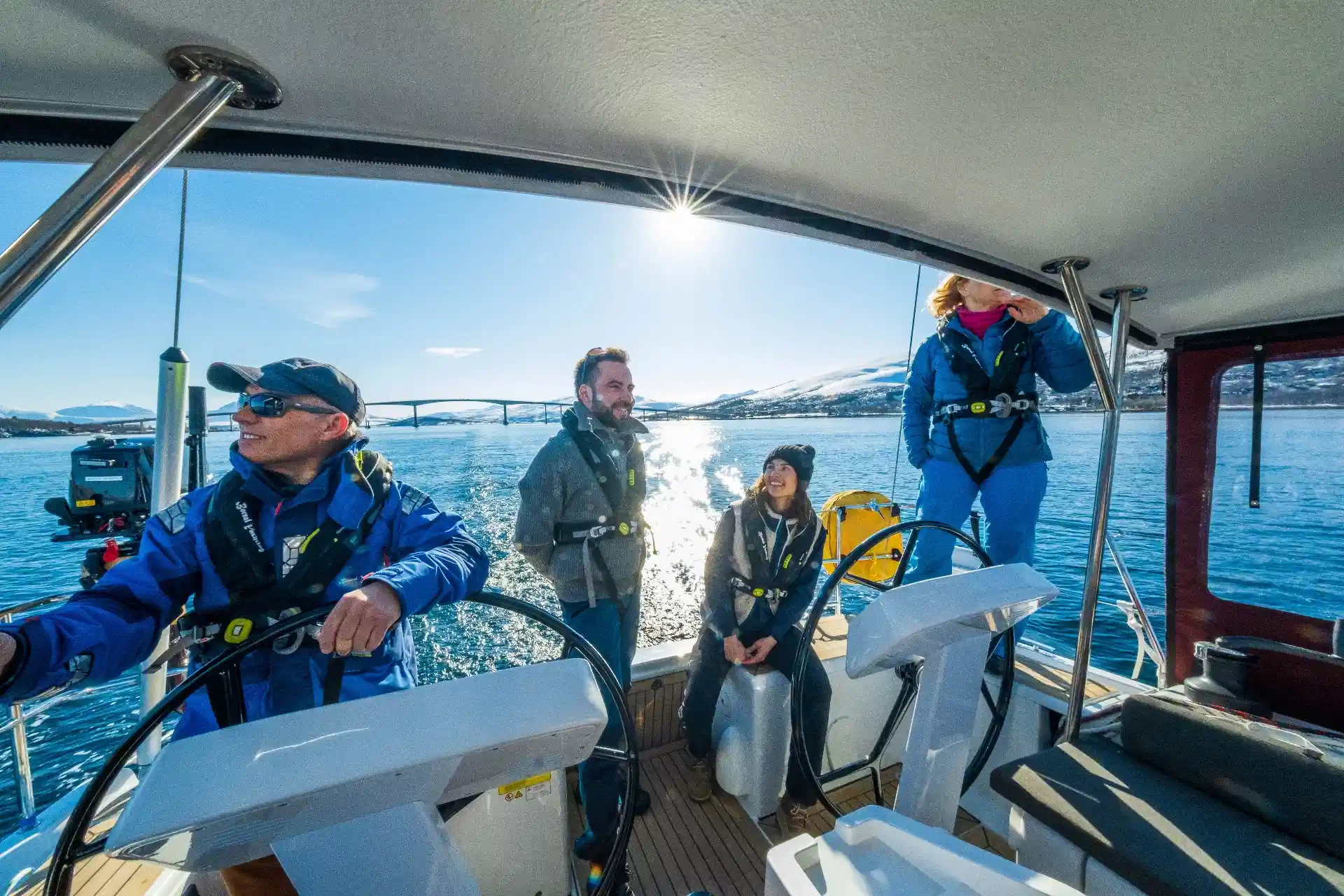Sailing yacht under way in a Northern Norwegian fjord with mountains behind